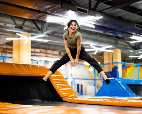 chica-guapa-saltando-trampolin-colorido-parque-infantil-posando-riendo-hermosa-mujer-t_143092-6329